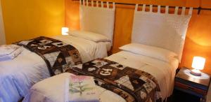 duas camas num quarto com duas lâmpadas numa mesa em "SA DOMO DE SOS ARANZOS" em Santa Maria la Palma