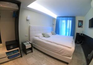 a bedroom with a white bed with a window at Sorrento Flats in Sorrento