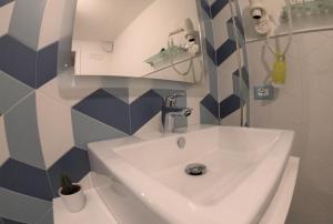 a bathroom with a white sink and blue and white tiles at Sorrento Flats in Sorrento