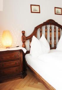 a bedroom with two beds and a dresser with a lamp at Stadthotel Restaurant Auerhahn in Vöcklabruck