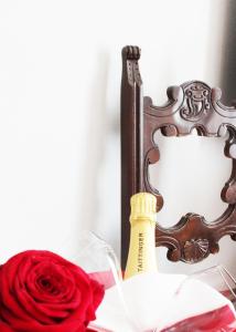 a bottle of champagne and a red rose in front of a mirror at Stadthotel Restaurant Auerhahn in Vöcklabruck
