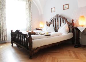 a bedroom with a wooden bed with white pillows at Stadthotel Restaurant Auerhahn in Vöcklabruck