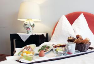 a tray with food on a bed with a lamp at Stadthotel Restaurant Auerhahn in Vöcklabruck