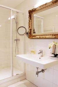 a bathroom with a sink and a shower at Stadthotel Restaurant Auerhahn in Vöcklabruck