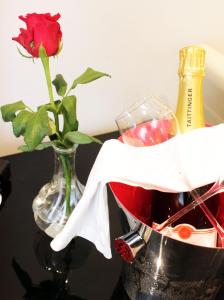 a vase with a rose and a bottle of wine at Stadthotel Restaurant Auerhahn in Vöcklabruck