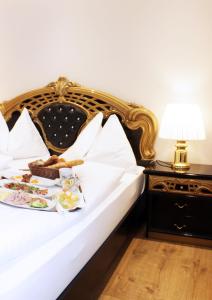 a white bed with a plate of food on it at Stadthotel Restaurant Auerhahn in Vöcklabruck