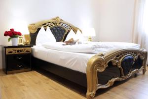 a bedroom with a large bed with a gold frame at Stadthotel Restaurant Auerhahn in Vöcklabruck