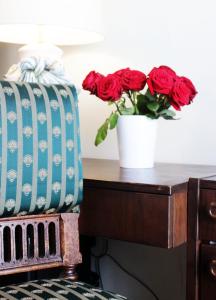 a vase of roses sitting on a desk with a vase of roses at Stadthotel Restaurant Auerhahn in Vöcklabruck