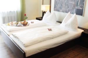 a bed with a tray of food on top of it at Stadthotel Restaurant Auerhahn in Vöcklabruck