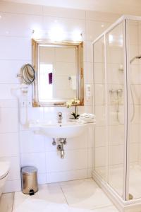 a bathroom with a sink and a shower at Stadthotel Restaurant Auerhahn in Vöcklabruck