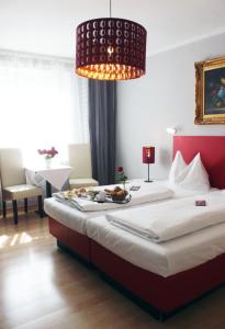 a bedroom with a large bed with a plate of food on it at Stadthotel Restaurant Auerhahn in Vöcklabruck
