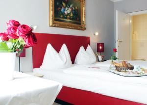 a hotel room with two beds with a plate of food at Stadthotel Restaurant Auerhahn in Vöcklabruck