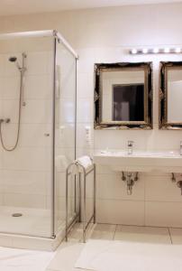 a bathroom with a shower and a sink at Stadthotel Restaurant Auerhahn in Vöcklabruck