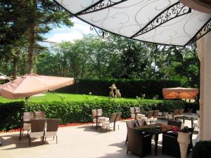 een patio met tafels en stoelen met een hond op de achtergrond bij Purple Star Apartments in Sveti Konstantin