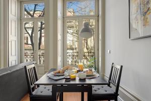 mesa de comedor con comida y zumo de naranja en OX Apartments B Arts, en Oporto