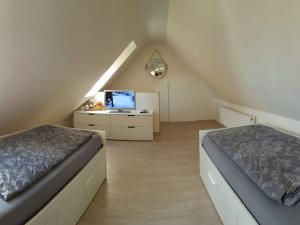 Schlafzimmer im Dachgeschoss mit 2 Betten und einem TV in der Unterkunft Modern Holiday Home in Wiek with Garden in Wiek auf Rügen 