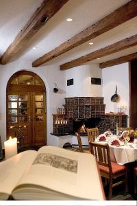 a room with a table with a book and a fireplace at Burghotel Stolpen in Stolpen