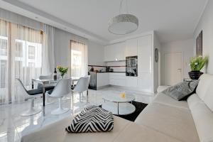 ein weißes Wohnzimmer mit einem weißen Sofa und einem Tisch in der Unterkunft Luxury Long Island Suite in Danzig