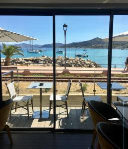 a view of a beach from a restaurant with a table and chairs at L'Escale Côté Sud in LʼÎle-Rousse