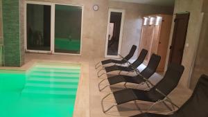 a group of chairs sitting next to a swimming pool at Amulett Wellness Apartman in Siófok