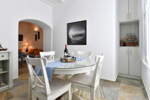 a white dining room with a table and chairs at Patriko Family House in Aliki