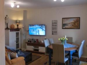 a living room with a table and a television on the wall at Villa Harmonie in Lohme