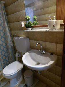 a bathroom with a white toilet and a sink at Teo 3 in Gouves