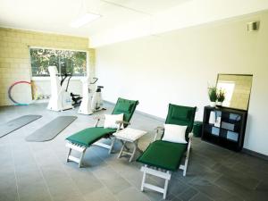um salão de cabeleireiro com cadeiras verdes e brancas em Forest view Apartment in Bollendorf with Large Balcony em Bollendorf