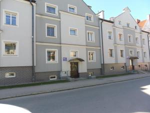 duży biały budynek na poboczu ulicy w obiekcie Kwatera Tolkmicko w mieście Tolkmicko