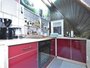 cocina con armarios rojos y fogones en Quaint Holiday Home in Elbingerode near Forest, en Neuwerk