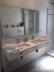 een badkamer met een wastafel met een spiegel en handdoeken bij Penthouse Asuncion Feria in Sevilla