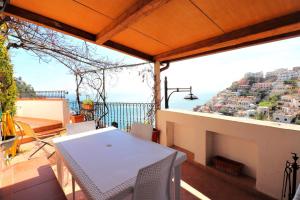 uma mesa numa varanda com vista para o oceano em Estate4home - MAISON LIRIO em Positano