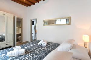 a white room with a bed and a mirror at Patriko Family House in Aliki