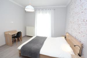 una camera con un letto bianco e un muro di mattoni di Oli's Luxury Apartment a Salonicco