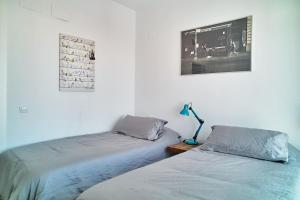 A bed or beds in a room at Fabulous Penthouse Downtown Tarifa, Maestro Apartments