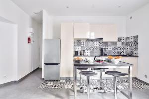 a kitchen with a table and a refrigerator at The Pearl Suite in Vitry-sur-Seine