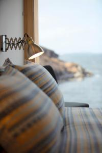 a bed with a pillow and a lamp next to a window at Tigh na Mara in Ullapool