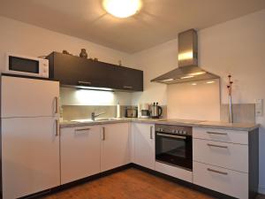 cocina con armarios blancos, fregadero y microondas en Modern Apartment in Brachthausen near Forest, en Brachthausen