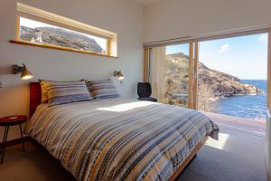 a bedroom with a bed with a view of the ocean at Tigh na Mara in Ullapool