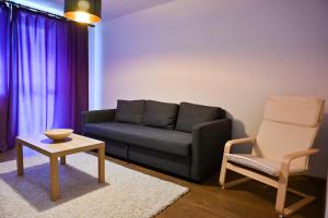een woonkamer met een bank en een stoel bij Sophia's Cozy Apartment in Mediaş