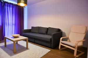 a living room with a couch and a chair at Sophia's Cozy Apartment in Mediaş
