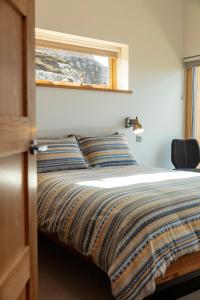 um quarto com uma cama com uma janela e uma cama sidx sidx em Tigh na Mara em Ullapool