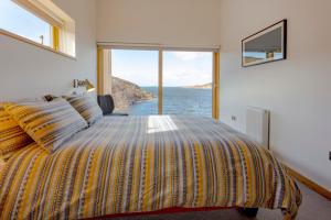 1 dormitorio con 1 cama y vistas al océano en Tigh na Mara, en Ullapool