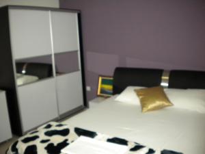 a room with a bed with a pillow and a mirror at Hotel Leder in Kočani