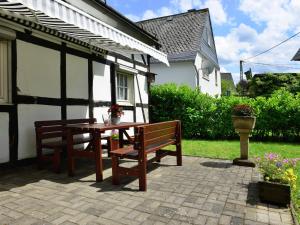 a wooden table and bench in front of a house at Bright apartment in the Sauerland with conservatory large terrace and awning in Assinghausen
