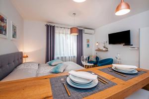 a living room with a bed and a table with plates on it at Studio Apartment Noah in Rovinj