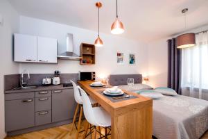 a kitchen and a bedroom with a bed and a table at Studio Apartment Noah in Rovinj