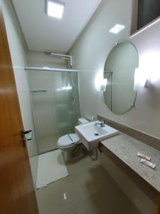 a bathroom with a toilet and a sink and a mirror at Guaratur Hotel in Linhares +38 photos