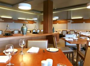 a restaurant with wooden tables and chairs with wine glasses at Monte Santo Resort in Carvoeiro