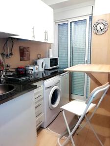 a kitchen with a washing machine and a table at Apartament's Veiga Tejo in Lisbon